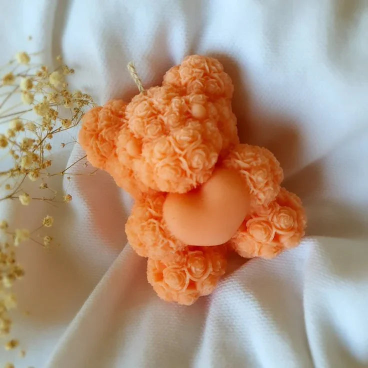 Peach floral teddy bear soy wax candle by Fiorance Luxe on white fabric with dried flowers