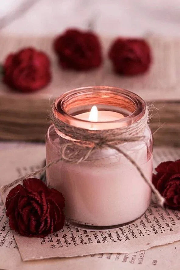 Luxury soy wax candle in glass jar with twine, surrounded by red flowers, Fiorance Luxe