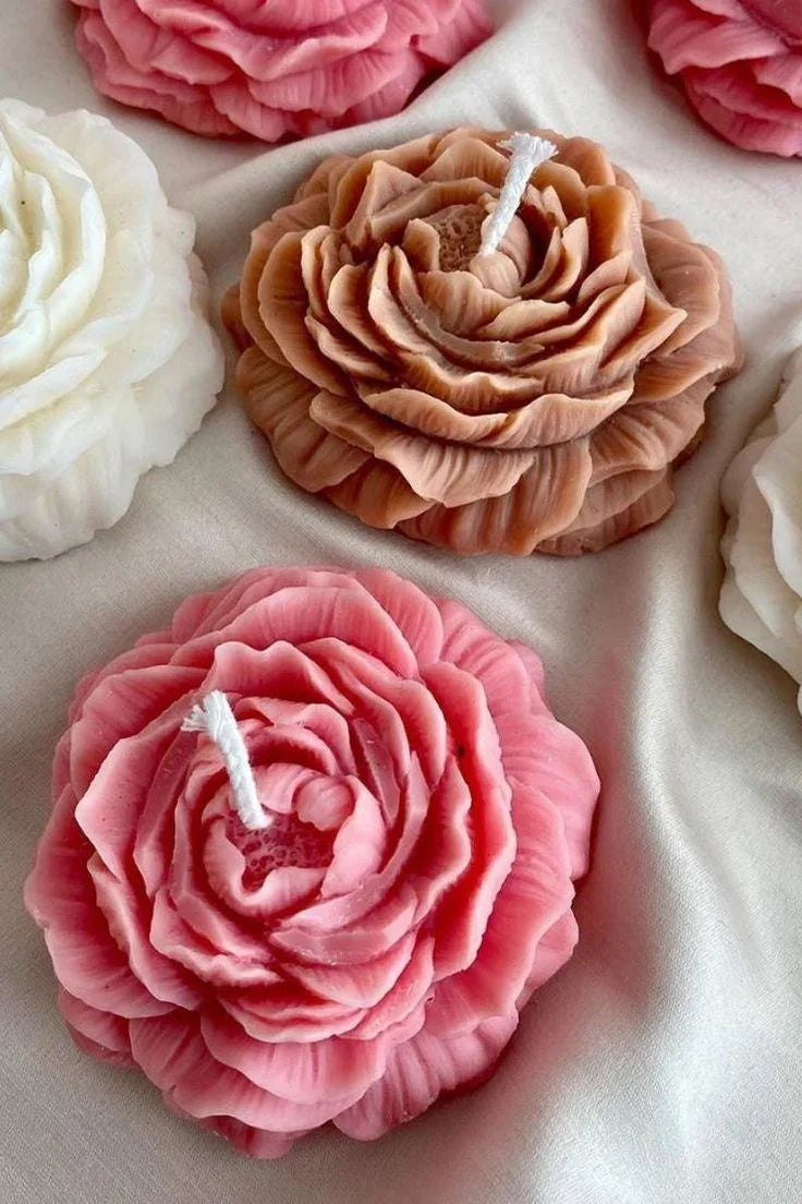 Decorative candles shaped like flowers on a white surface