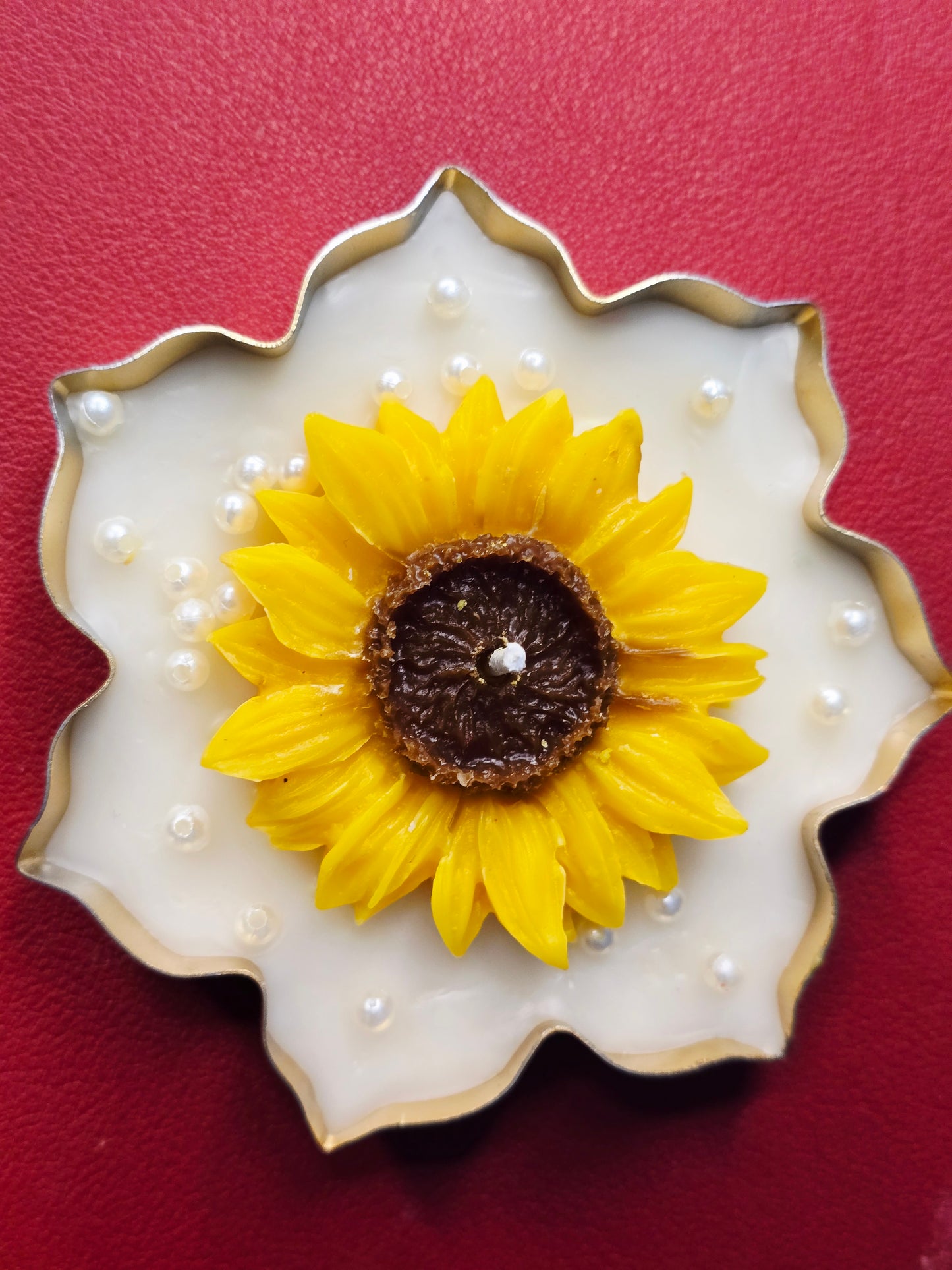 Sunflower-shaped soy wax candle with pearl accents on red, luxury Fiorance Luxe decor.