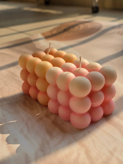 Pink and peach bubble soy wax candles from Fiorance Luxe on sunlit marble surface