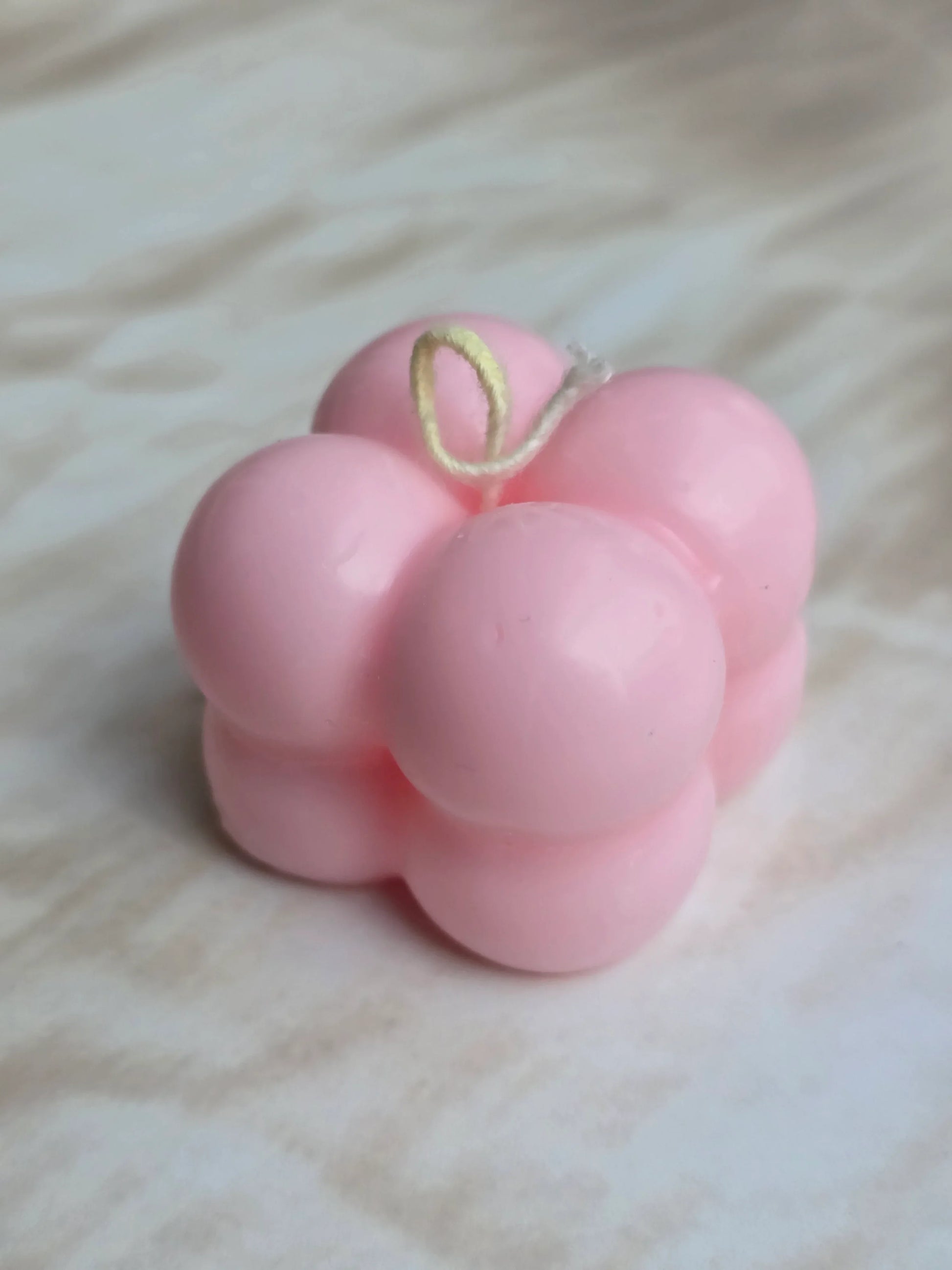 Pink bubble soy wax candle by Fiorance Luxe on a marble surface, luxury floral decor