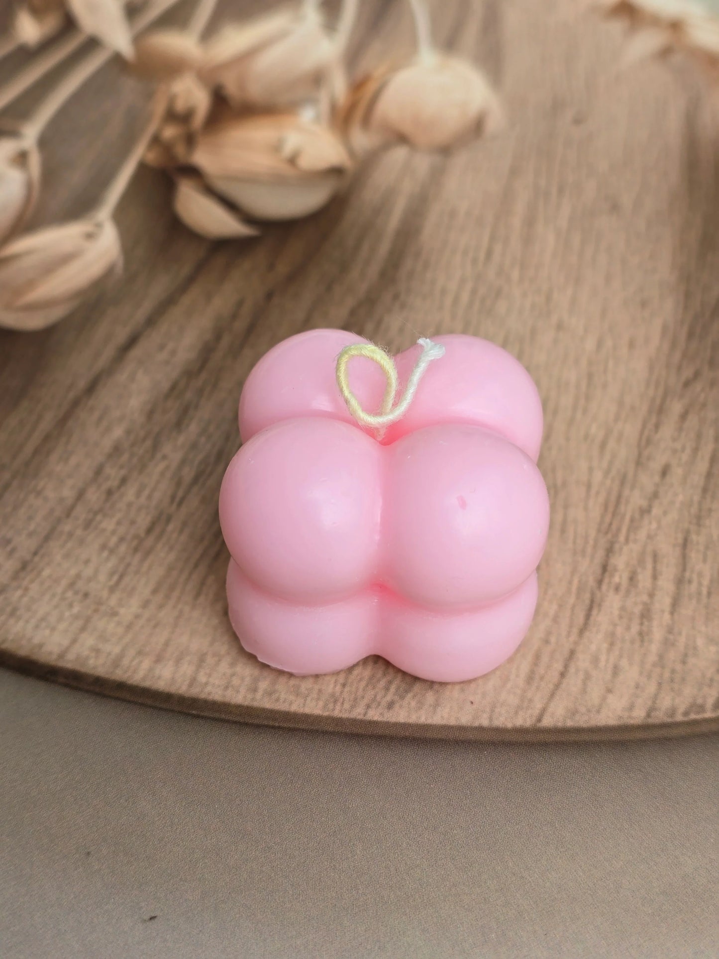 Pink bubble soy wax candle by Fiorance Luxe on wooden tray with dried flowers