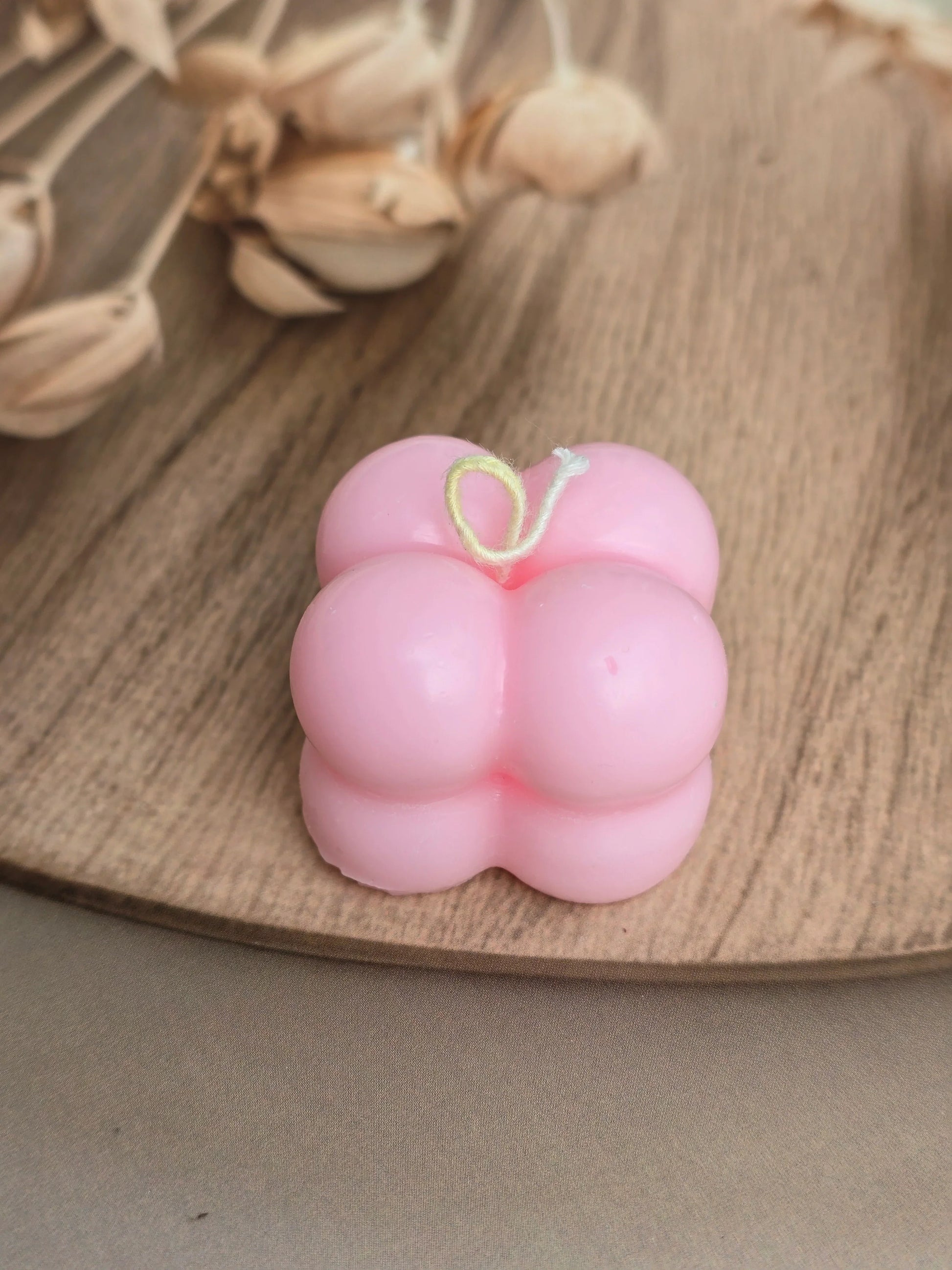 Pink bubble soy wax candle by Fiorance Luxe on wooden tray with dried flowers