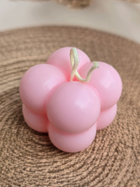 Pink bubble-shaped soy wax candle from Fiorance Luxe on a woven mat