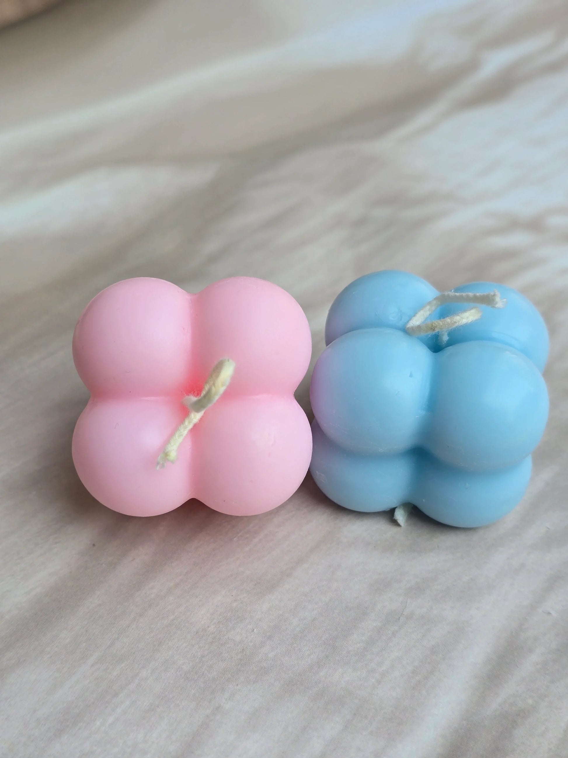 Pink and blue bubble soy wax candles from Fiorance Luxe on a light surface