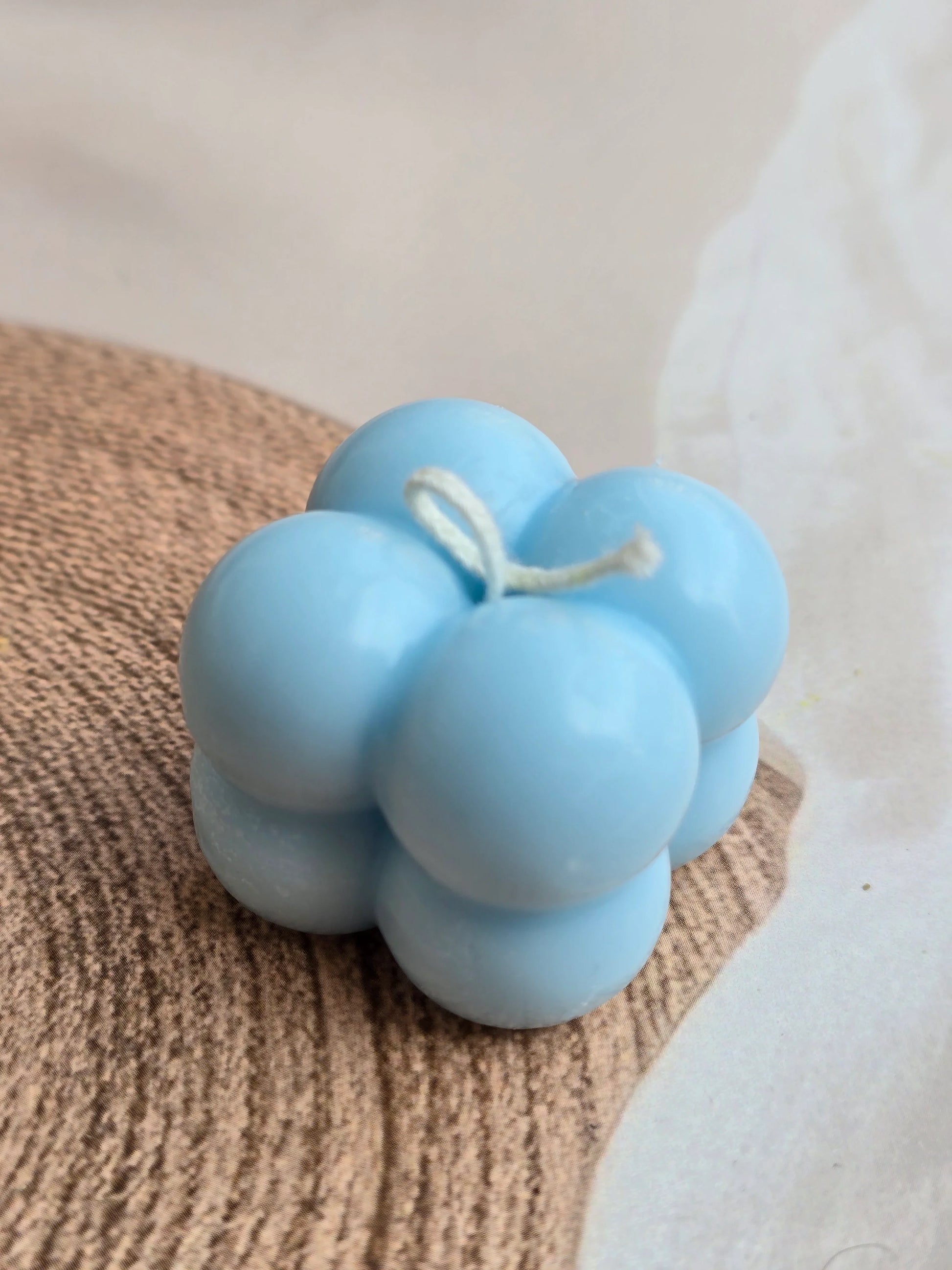 Blue bubble soy wax candle from Fiorance Luxe on a neutral tabletop