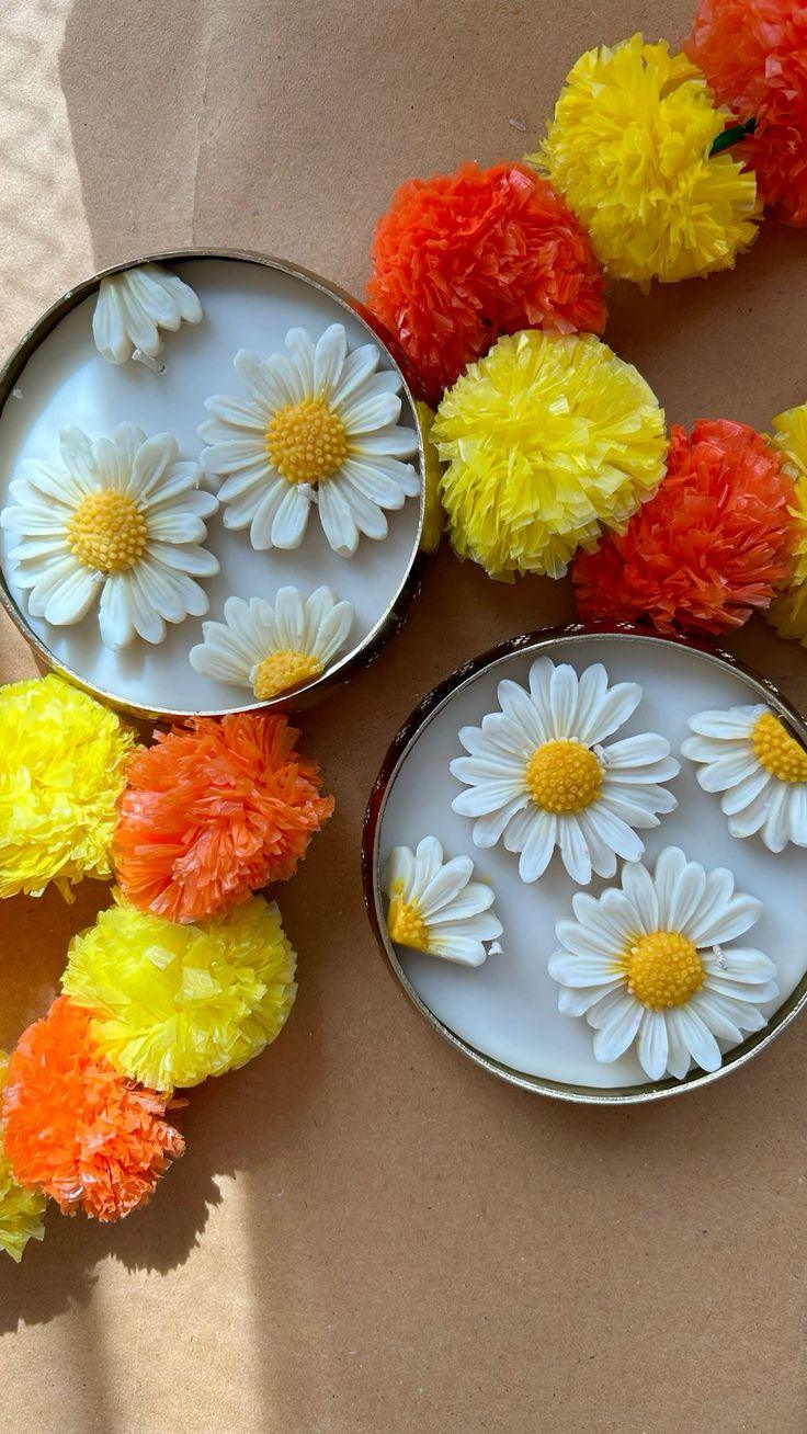 Two containers with floral designs on a brown background