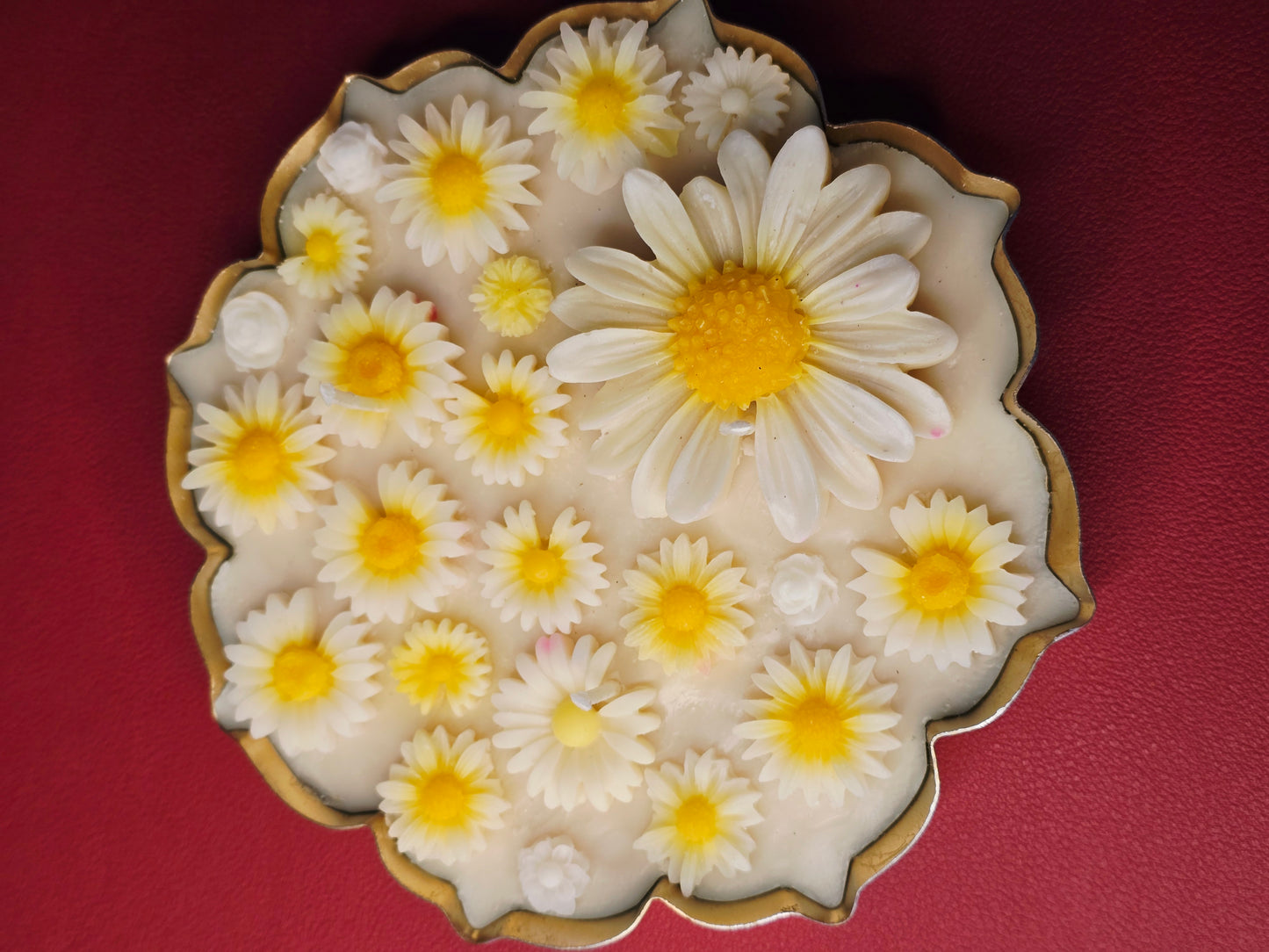 Fiorance Luxe floral soy wax candle with yellow and white daisy decorations on red background