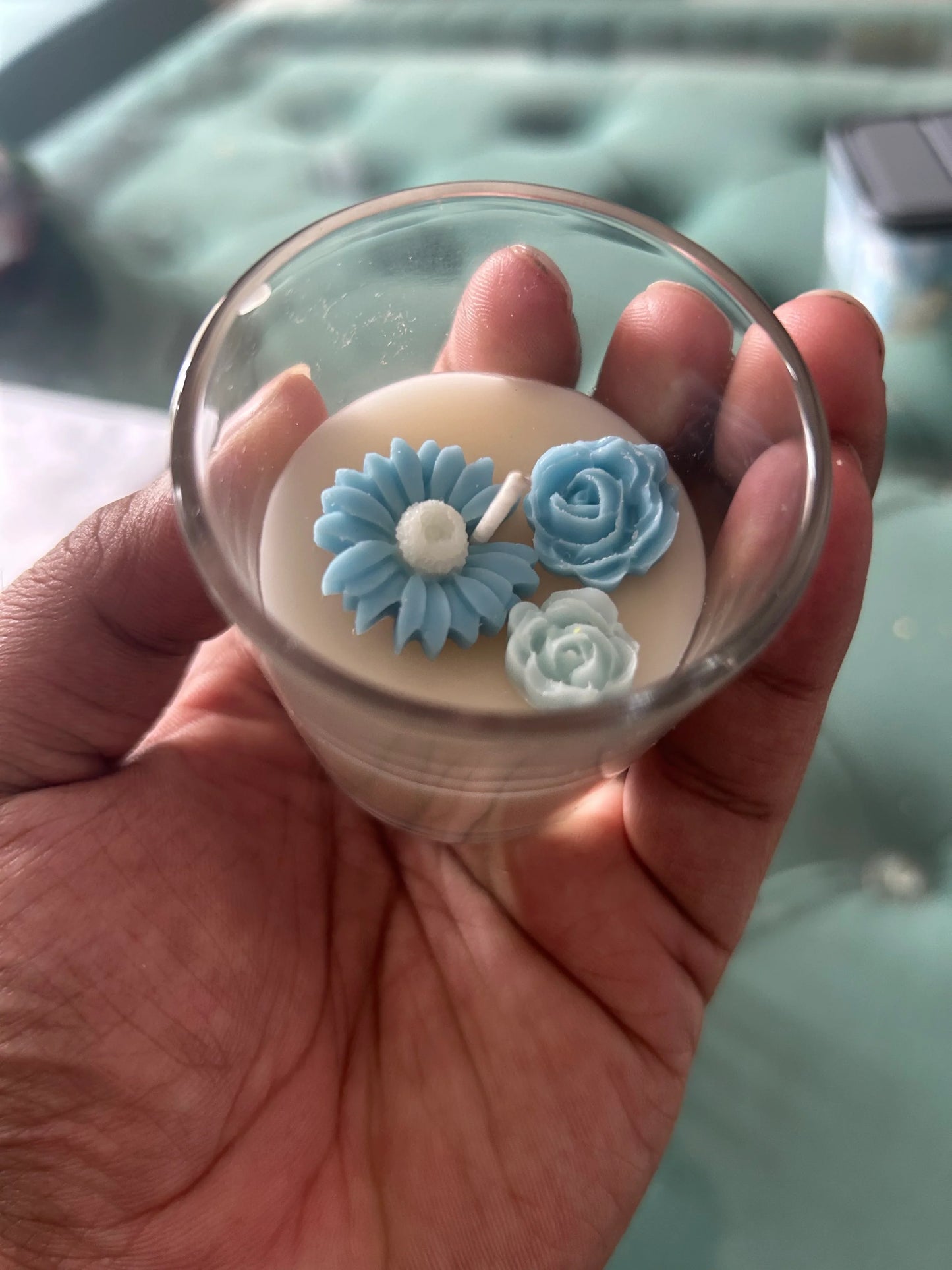 Hand holding Fiorance Luxe luxury soy wax candle with blue floral design in glass cup
