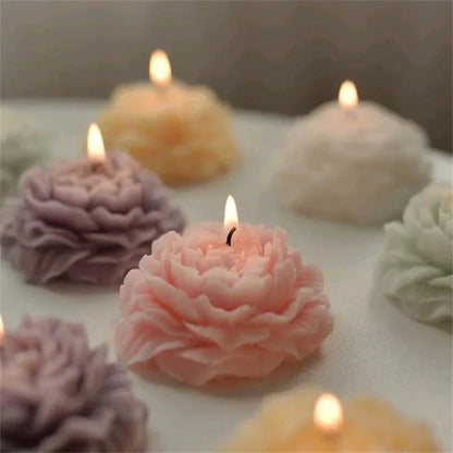 Decorative flower-shaped candles on a soft surface with a neutral background