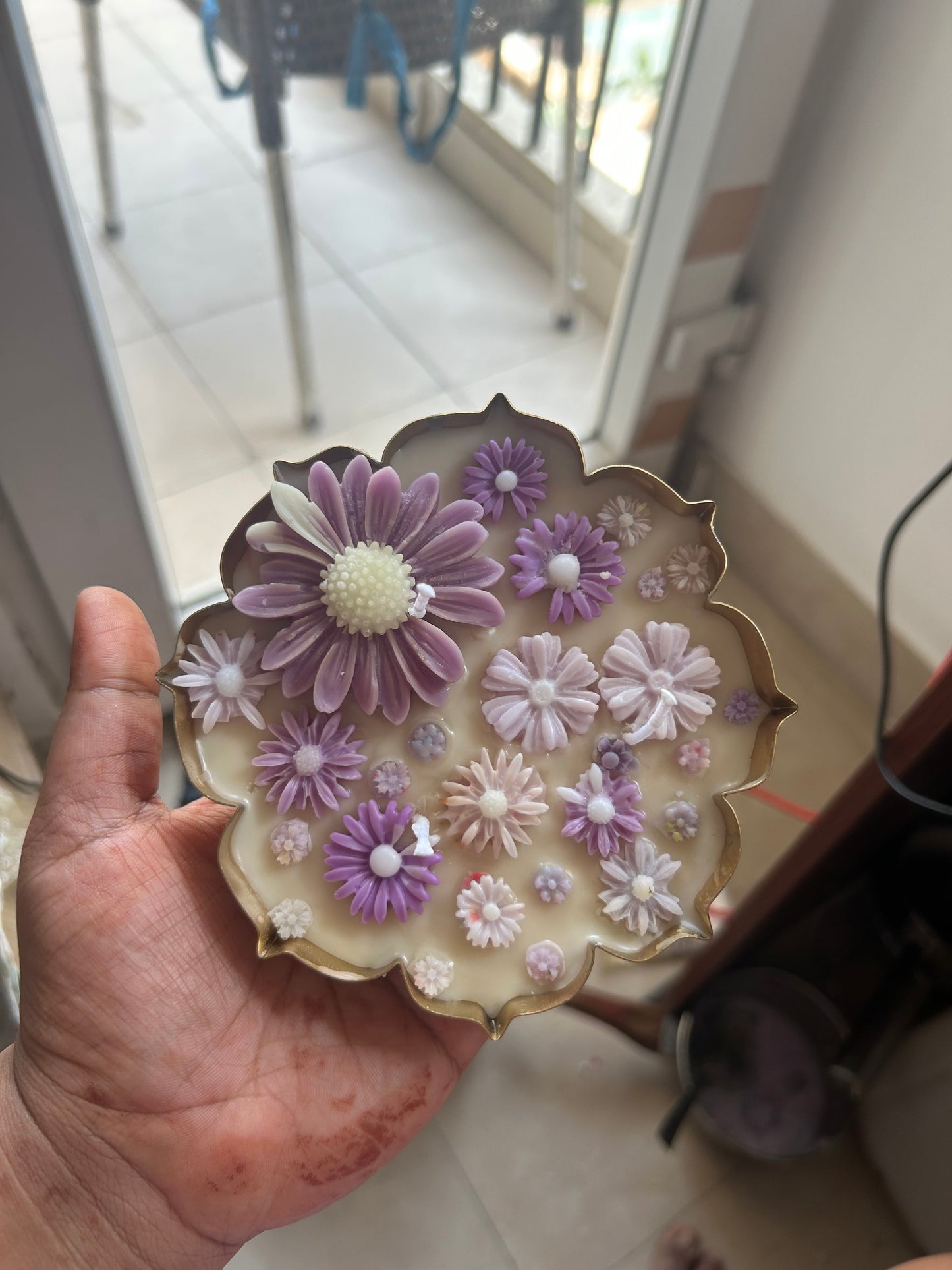 Hand holding a luxury floral soy wax candle with purple and white flowers, Fiorance Luxe