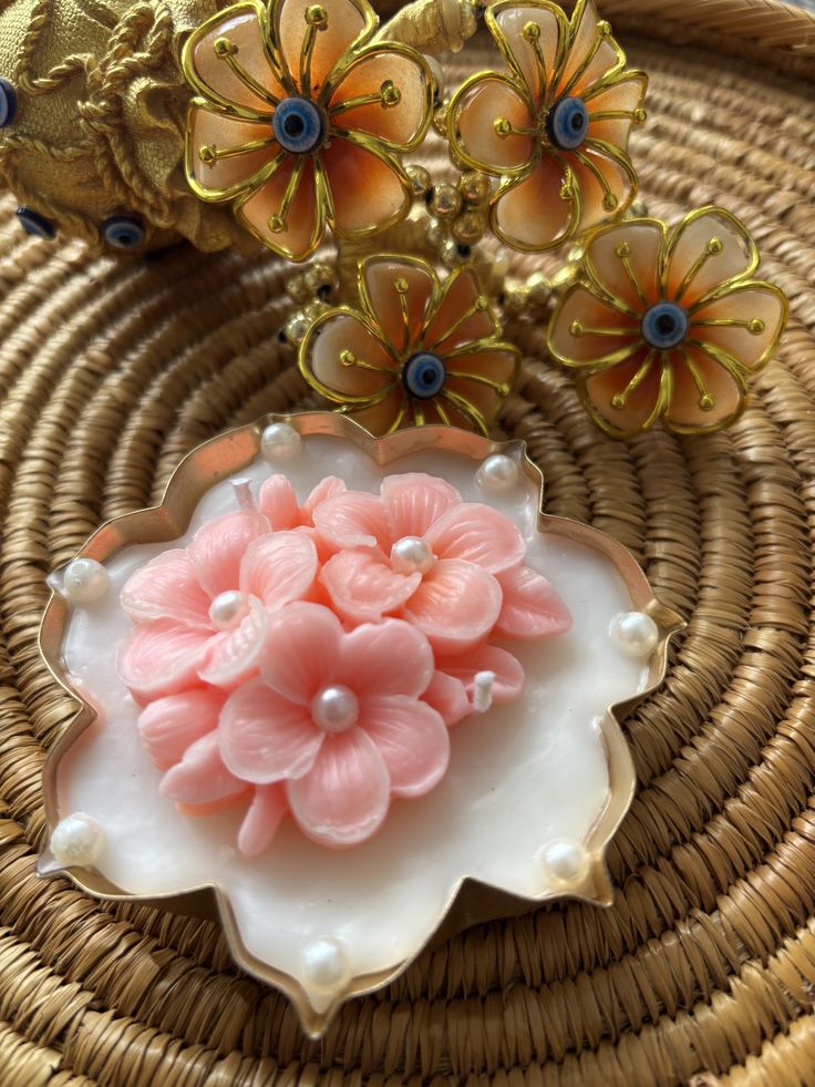 Luxury Fiorance Luxe soy wax floral candle with pink flowers in an ornate holder on wicker mat