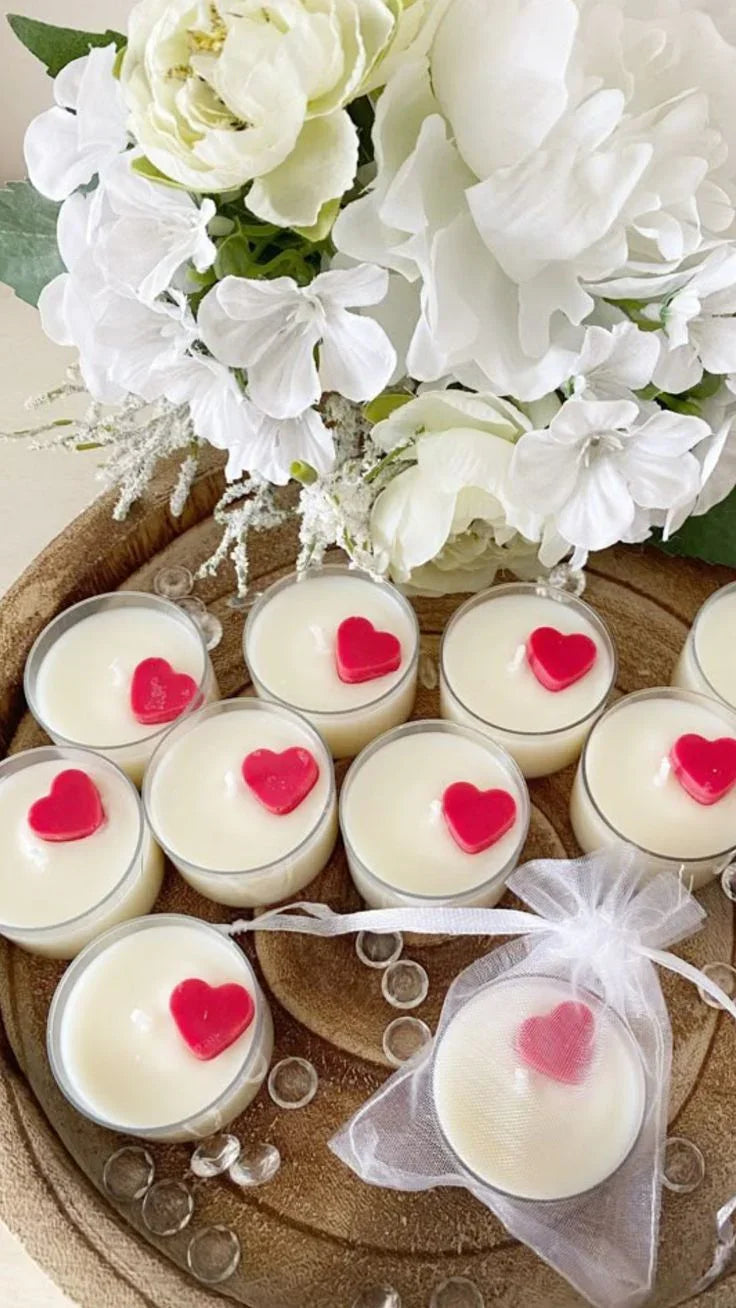 Fiorance Luxe soy wax candles with red heart toppers on a wooden tray, white floral decor.