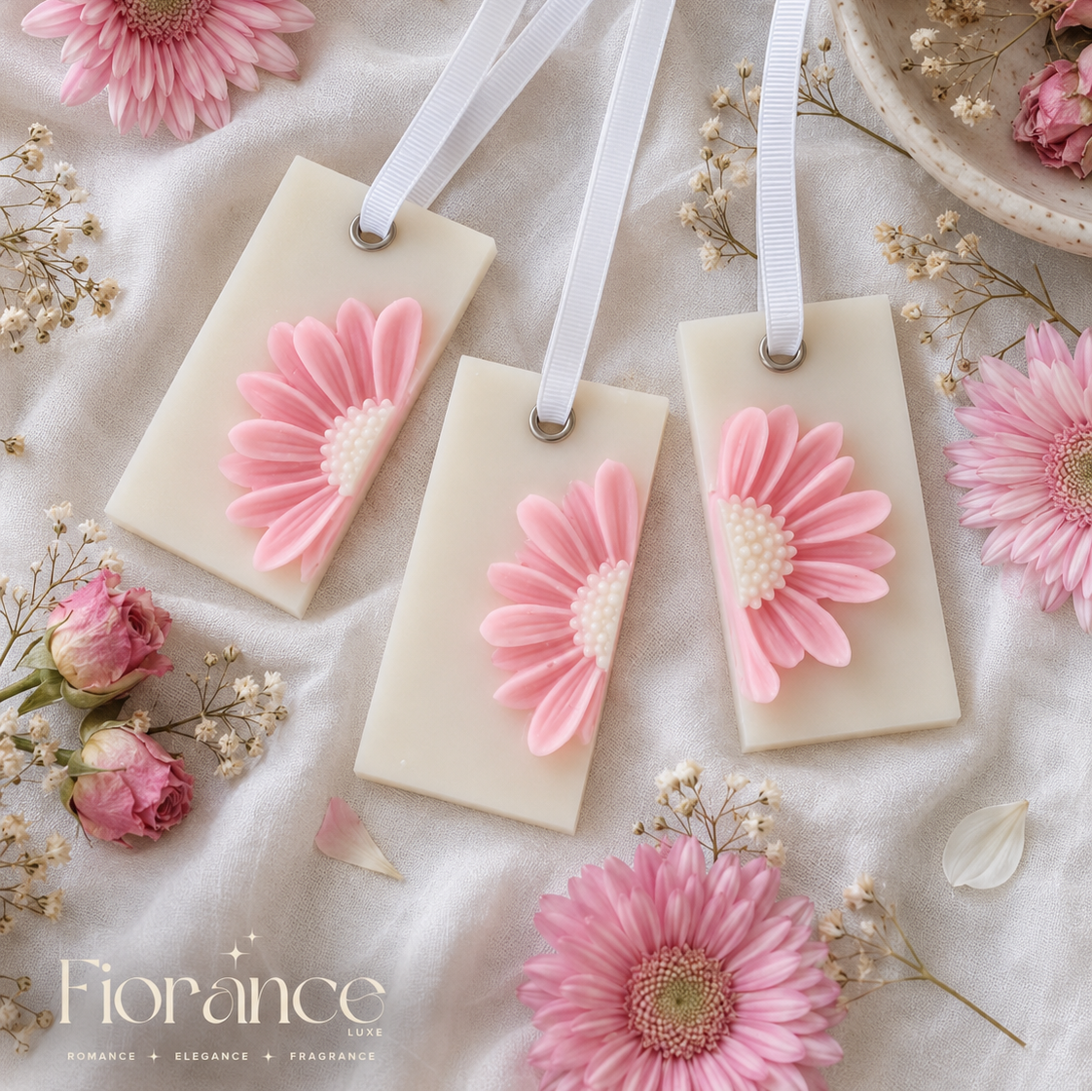 Daisy wax sachets with pink floral designs on a soft white background with flowers and ribbons.