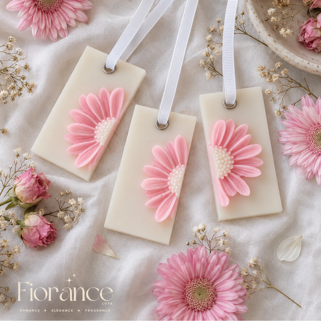 Daisy wax sachets with pink floral designs on a soft white background with flowers and ribbons.