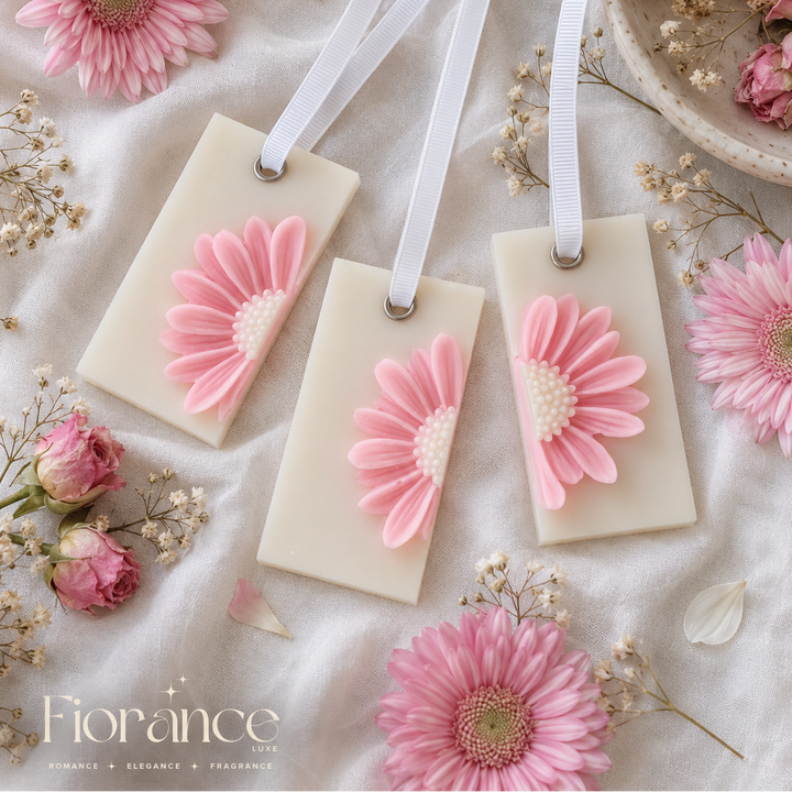 Daisy wax sachets with pink floral designs on a soft white background with flowers and ribbons.