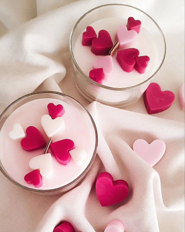 Fiorance Luxe luxury soy wax candles in glass jars with pink and white heart designs on fabric.