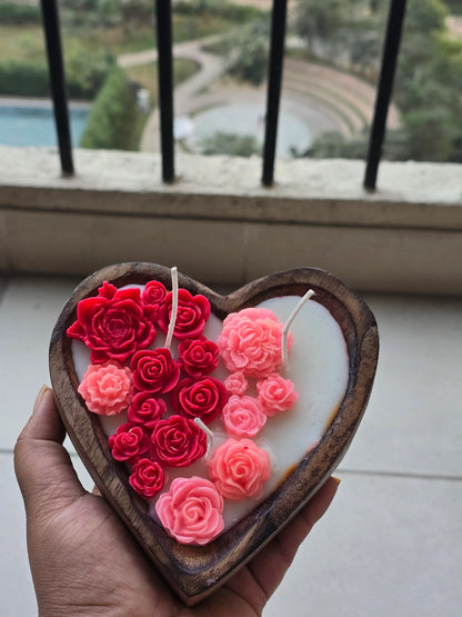 Hand holding Fiorance Luxe heart-shaped soy wax floral candle with red and pink rose designs