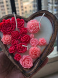 Heart-shaped Fiorance Luxe soy wax candle with pink and red floral designs in a wooden holder