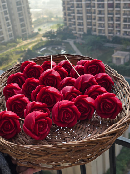 Basket of red rose-shaped Fiorance Luxe soy wax candles on balcony, cityscape background
