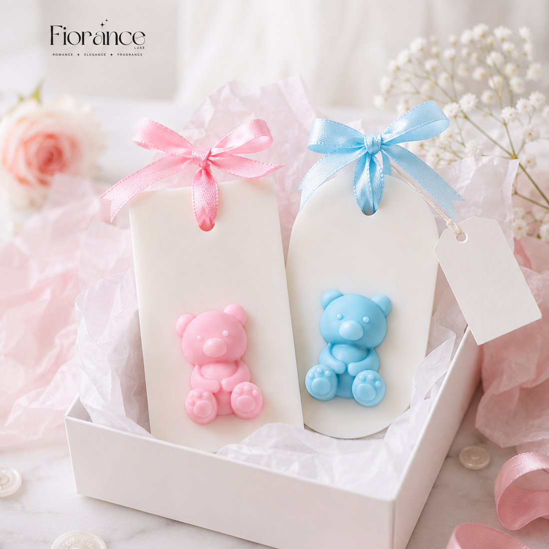Two small bottles with pink and blue bear figurines on a wax sachet with ribbons and flowers.