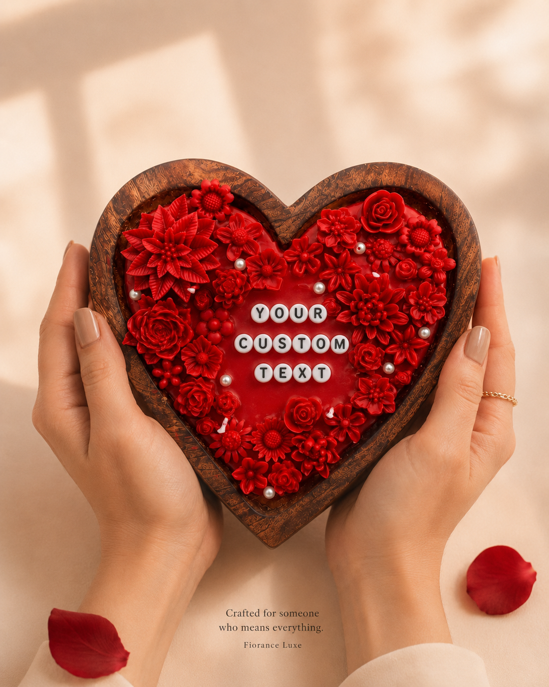 Heart-shaped wooden box with red floral design held by hands on a beige background